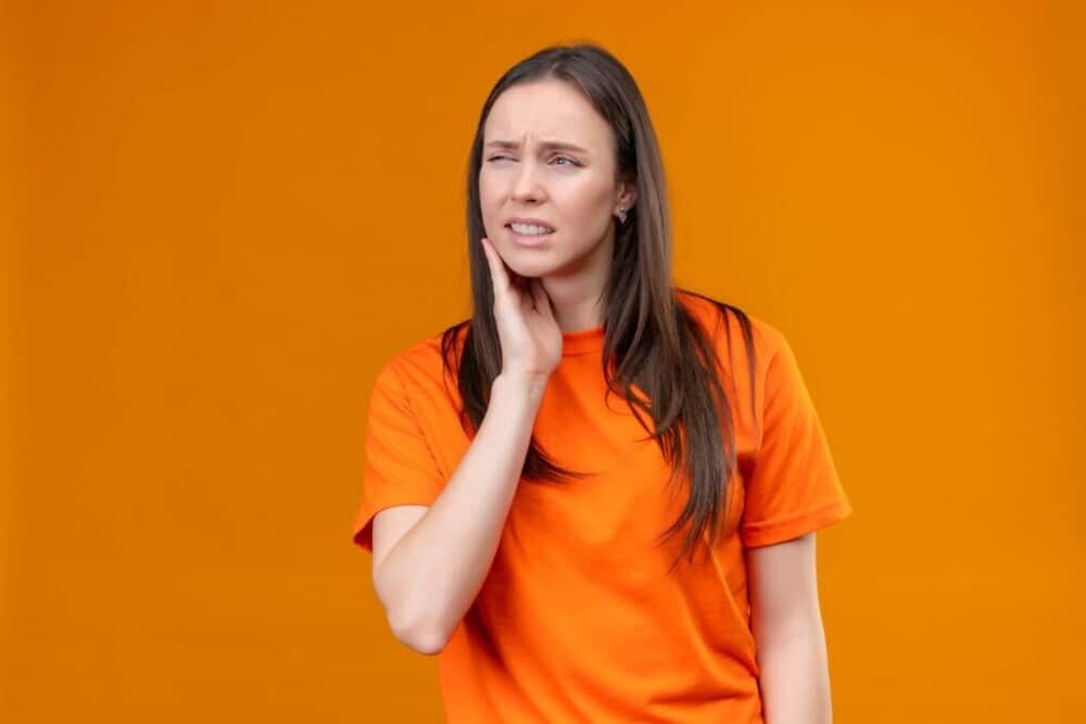 Chica vestida de naranja tiene dolor en la atm Imagen destacada del artículo