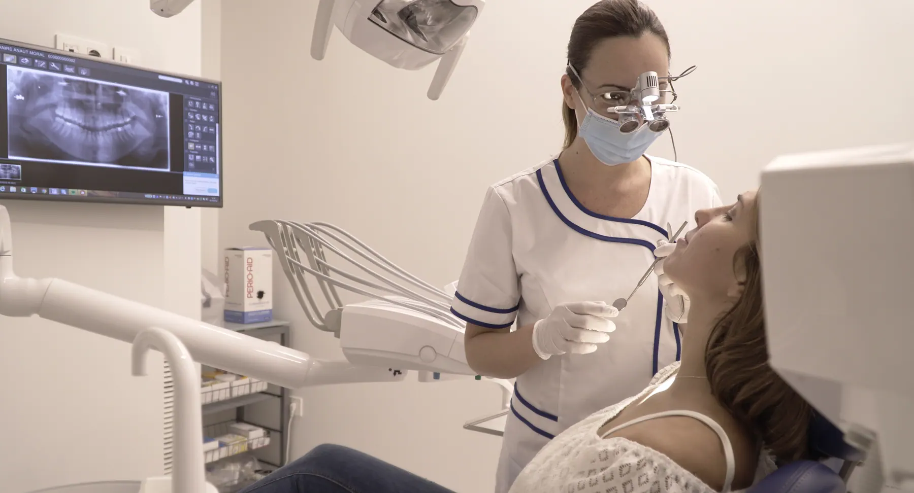 Higienista dental atendiendo a una paciente en el gabinete