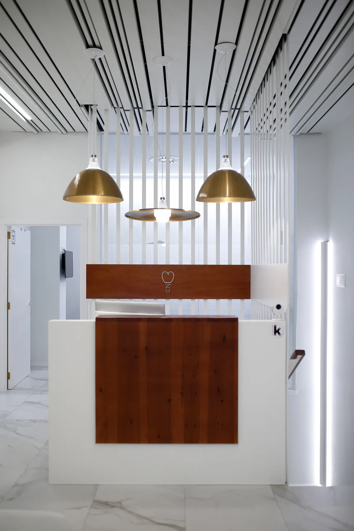 Mostrador de la clínica dental con panel de madera y logotipo