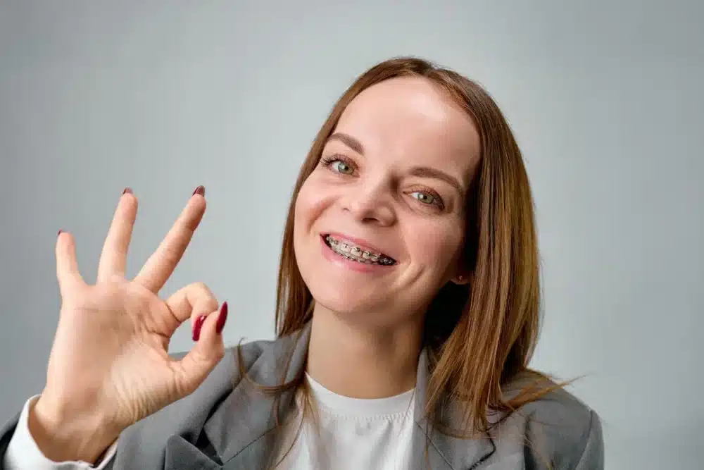 Persona contenta mostrando sus brackets metalicos Imagen destacada del artículo